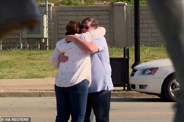 People are pictured embracing following the mass shooting at the Old National Bank