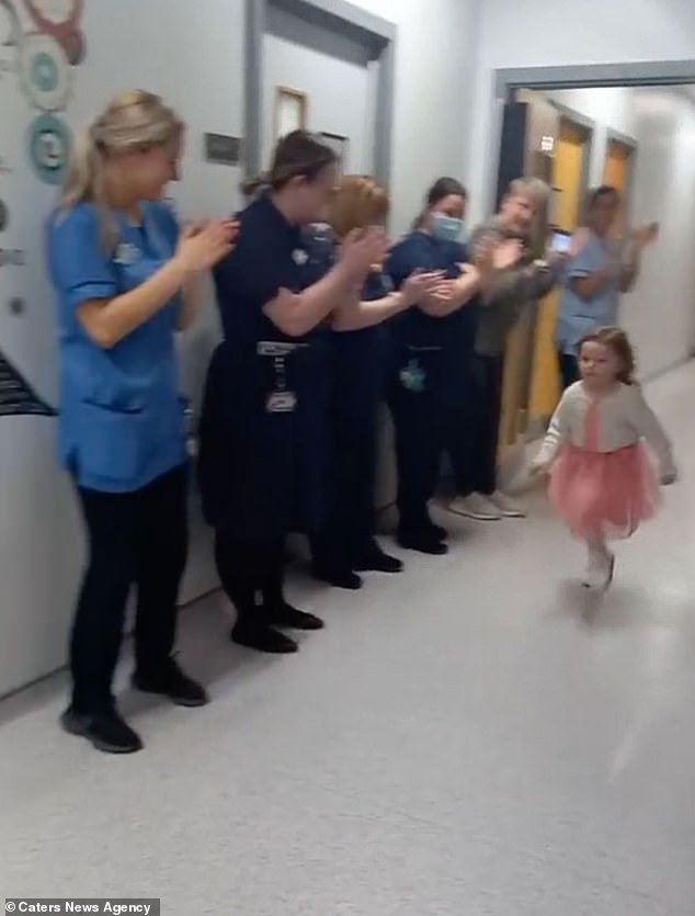 Ihre Mutter hielt den herzerwärmenden Moment fest, als ihre Tochter die behandlungsfreie Glocke läutete, umgeben von Krankenschwestern, die Phoebe anfeuerten und klatschten