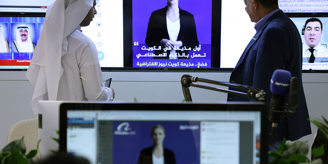 Journalisten sehen sich am 9. April 2023 in Kuwait-Stadt ein Einführungsvideo des „Künstliche-Intelligenz“-Moderators Fedha auf dem Twitter-Account des kuwaitischen Nachrichtendienstes an. (Foto von YASSER AL-ZAYYAT/AFP) (Foto von YASSER AL-ZAYYAT/AFP über Getty Images)