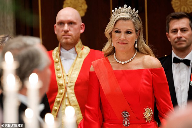The Dutch Queen looked glamourous in her crimson gown and pearl tiara, which matched her necklace and earrings