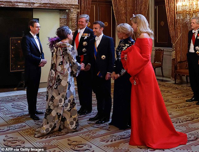 Earlier today Maxima, pictured at the banquet, was beaming as she shook hands with Brigitte, before the group stood side-by-side to watch the guard of honor