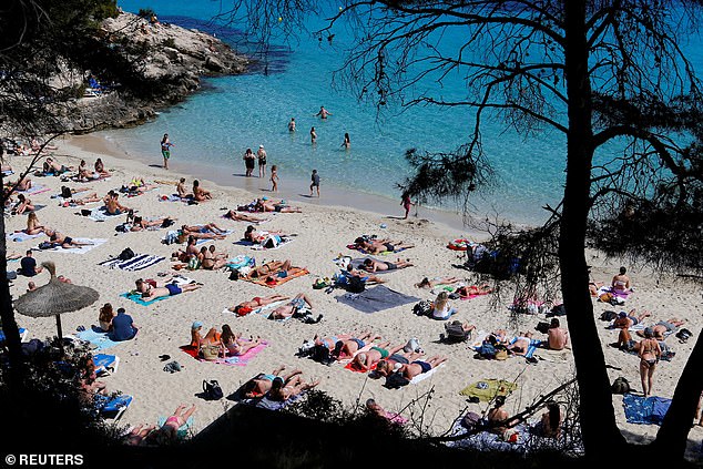 The Spanish island of Mallorca has moved to limit hotel beds to 430,000 in attempt to have 'tourism of greater value and less volume'. Pictured: People enjoy the sunny weather on Illetas beach, on the Balearic island of Mallorca, Spain last week