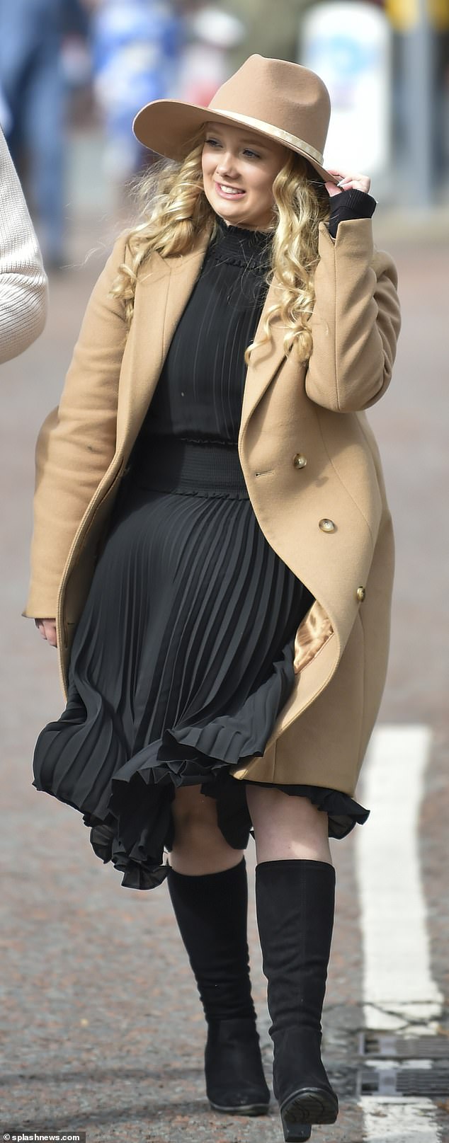 A classic combo: This woman opted for a black pleated dress and black knee-high boots which she paired with a camel coat and a camel hat