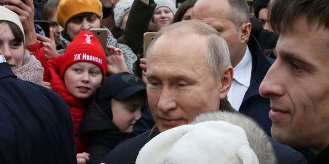 Der russische Präsident Wladimir Putin umarmt ein weinendes Baby, als er am 6. März 2020 Einwohner in Iwanowo, Russland, begrüßt. (Mikhail Svetlov / Getty Images)