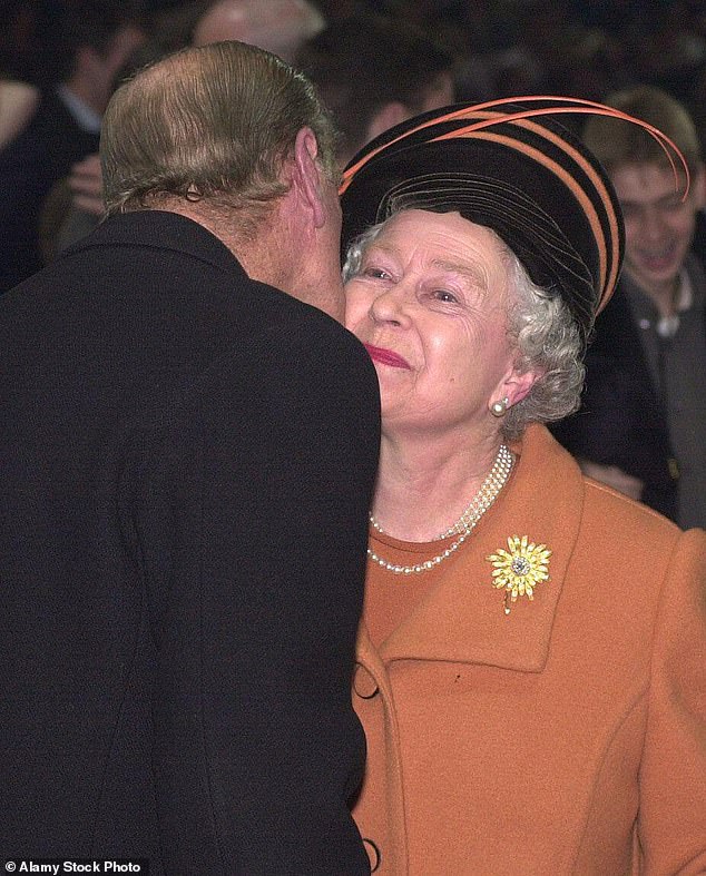 The Duke of Edinburgh is pictured kissing Queen Elizabeth II during the midnight celebrations at the Millennium Dome in Greenwich in London
