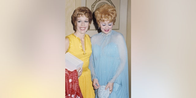 Carol Burnett in einem gelben Kleid neben Lucille Ball in einem blauen Kleid