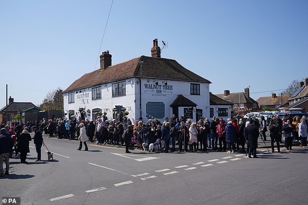 Wellwishers at the Walnut Tree Pub in Aldington, Kent, where Paul O'Grady would enjoy a drink, gather to see his coffin pass with their dogs