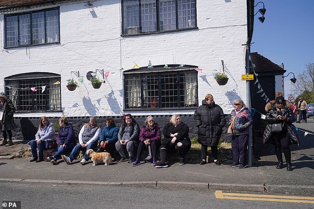 Fans wait outside the Walnut Tree Pub in Aldington, Kent, for the funeral cortege of Paul O'Grady to pass by on its way for his funeral service at St Rumwold's Church