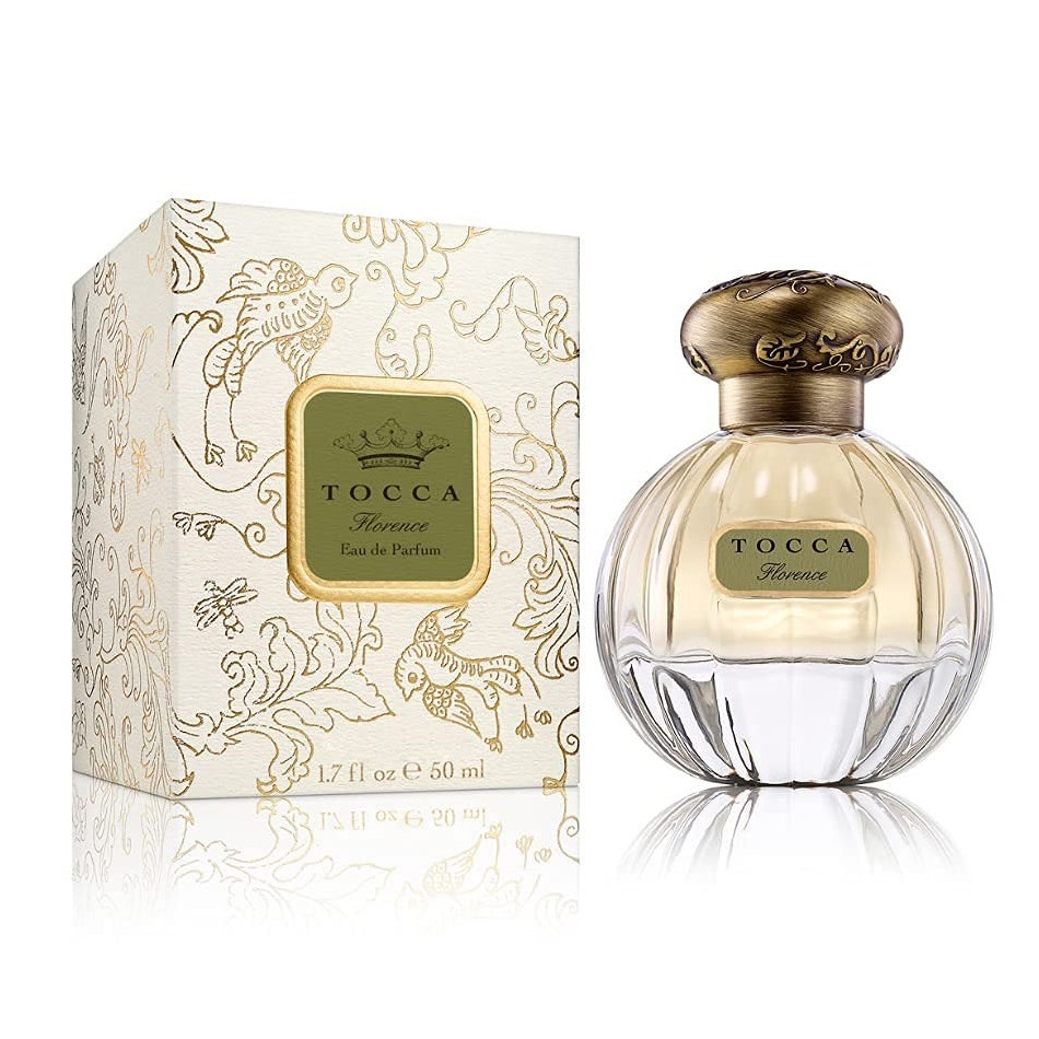 Tocca Florence Eau de Parfum runde Flasche hellgelbes Parfüm mit goldener Kugelkappe und beiger Tapetenbox auf weißem Hintergrund