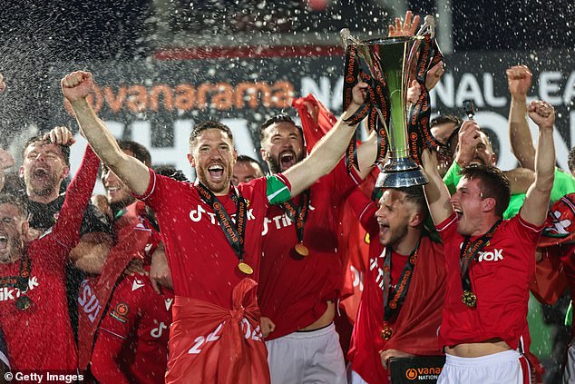 Congratulations! Wrexham FC players lift the Vanarama National League Trophy as they celebrate promotion back to the English Football League 15 years after being demoted