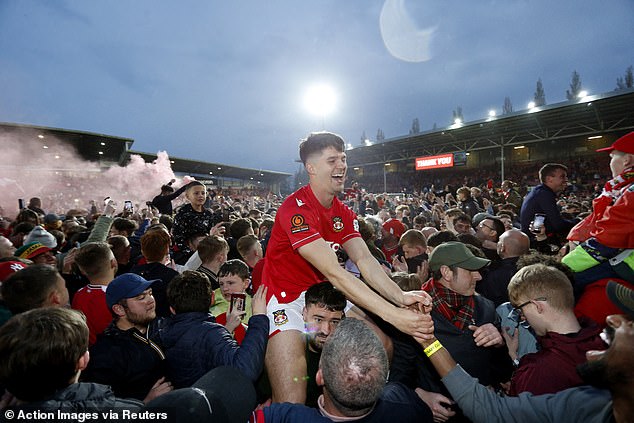 Dreamland: A fan hold a Wrexham football player on his shoulders in jubilation over their win