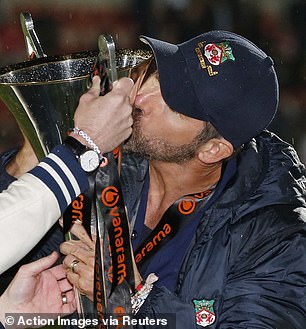 Unreal: Kitted in their Wrexham team gear, the co-owners kiss the Vanarama National League Trophy after the huge win (Reynolds pictured)