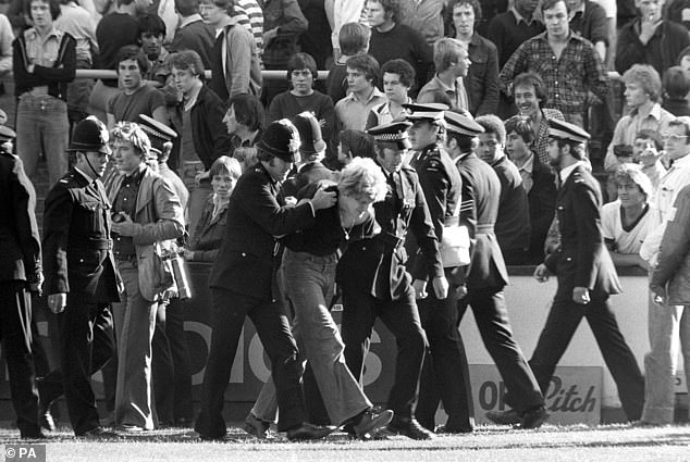 Pictured: police removing football fans after a fight erupted during a game between Millwall and rivals West Ham at Upton Park in July, 1978