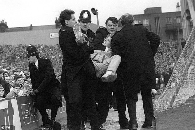 Bob claimed he joined Millwall's firm when he was just 11, having his first fight at 13. Pictured is a fan being pulled out of the crowd at the start FA Cup third round match between Arsenal and Millwall in January 1988