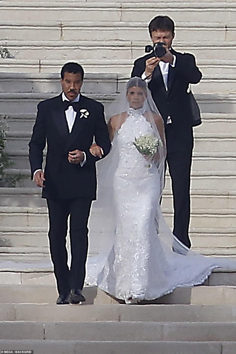 Stunning: On her big day, the model, 24, looked sensational in a beaded ivory gown as her dad sweetly walked her down a flight of stairs as she prepared to marry British music executive, Elliot Grainge