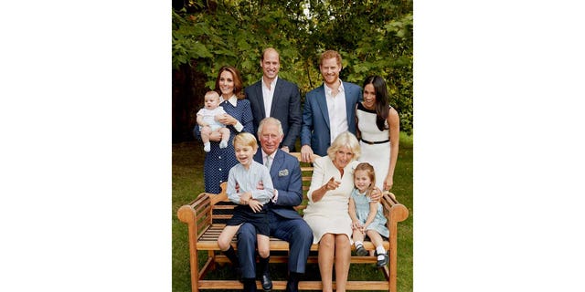 Die königliche Familie wird auf einem Bild zum 70. Geburtstag von König Charles fotografiert, auf dem König Charles und Camilla mit Prinz George und Prinzessin Charlotte auf einer Bank sitzen, während Kate Middleton ein Baby Prinz Louis neben Prinz William neben Prinz Harry und Meghan Markle hält