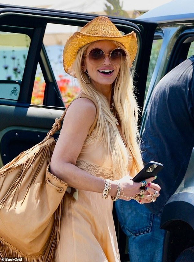 Alle lächeln!  Jessica – deren Stilikone Dolly Parton ist – trug ihre charakteristischen flachsfarbenen Locken für den Familienausflug, und sie rockte eine massive Sonnenbrille und einen Überschuss an Schmuck