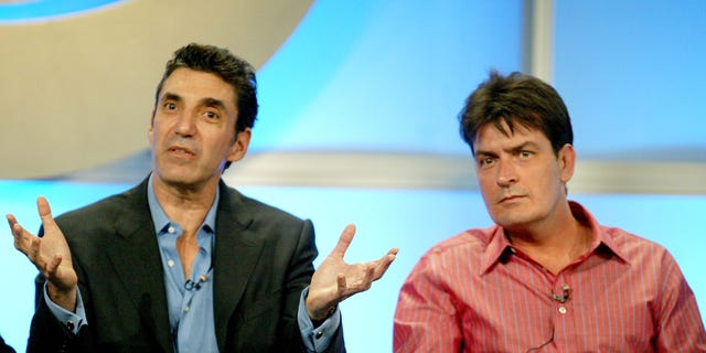 Chuck Lorre and Charlie Sheen sit next together on stage