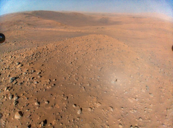 Ein Bild des Mars, das vom Ingenuity-Hubschrauber aus der Luft aufgenommen wurde, mit dem Perseverance-Rover oben links.