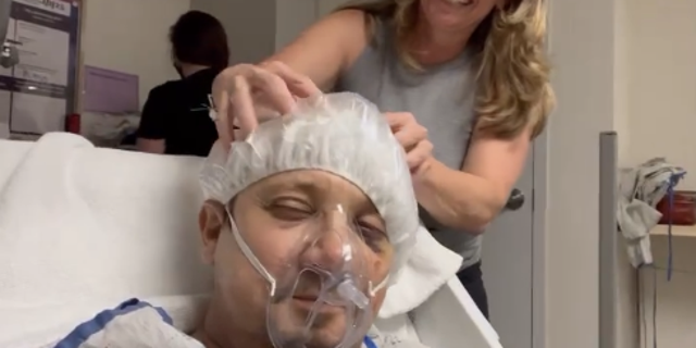 Jeremy Renner teilte ein Foto von sich, wie er sich den Kopf massieren ließ, während er ein Haarnetz trug, eine medizinische Atemmaske trug und sich auf das Krankenhausbett legte.  Er dankte seiner Mutter und seiner Schwester für ihre Liebe.