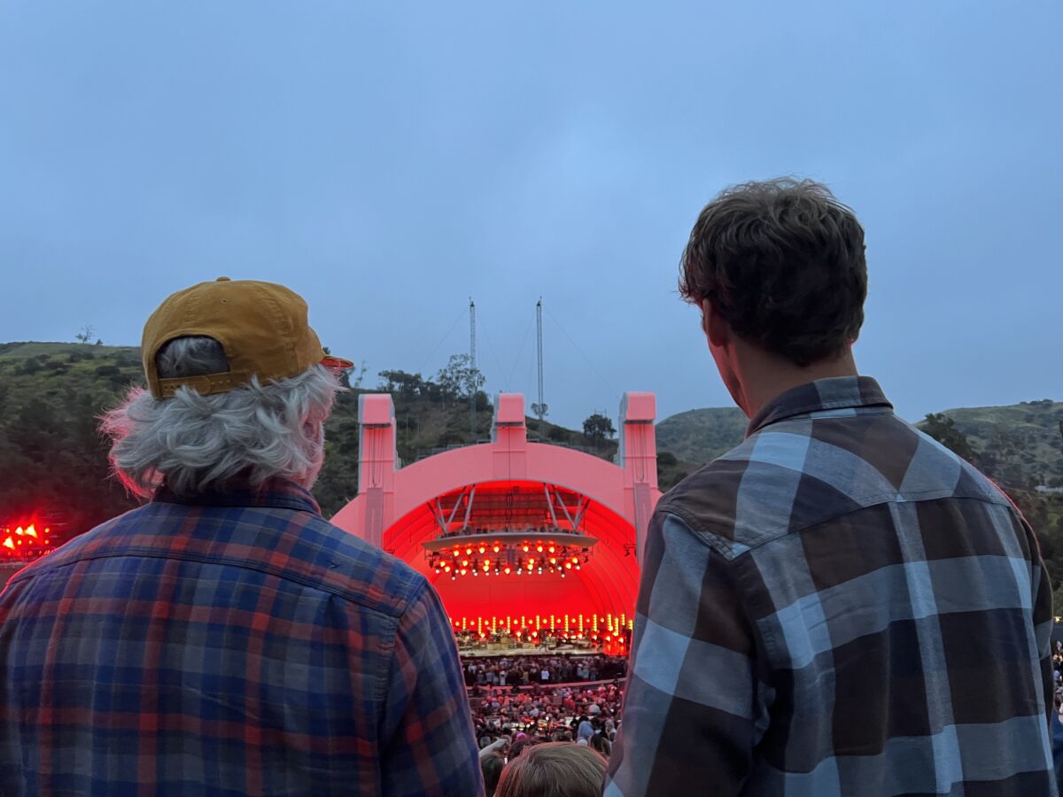 Die Ansicht von zwei Männern in karierten Hemden von hinten, die auf die Hollywood Bowl blicken.