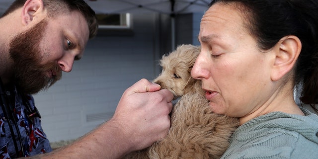 Tierarzttechniker Justin Jones (L) gibt einem Hund namens Sadie eine Hunde-Influenza-Immunisierung