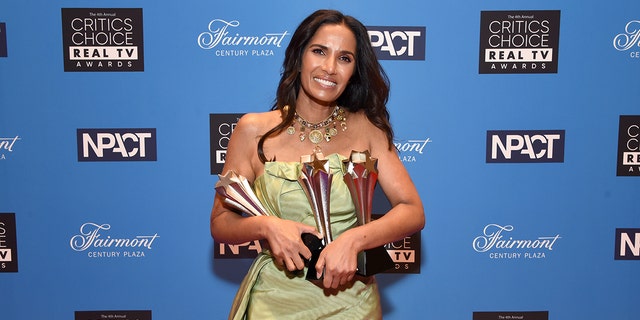 Padma Lakshmi trägt ein leichtes, ärmelloses Kleid mit einer Reihe von Auszeichnungen