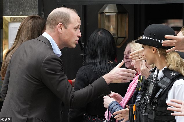 Meanwhile Prince William reached into the crowd to offer a hand to fans who were waiting in Soho