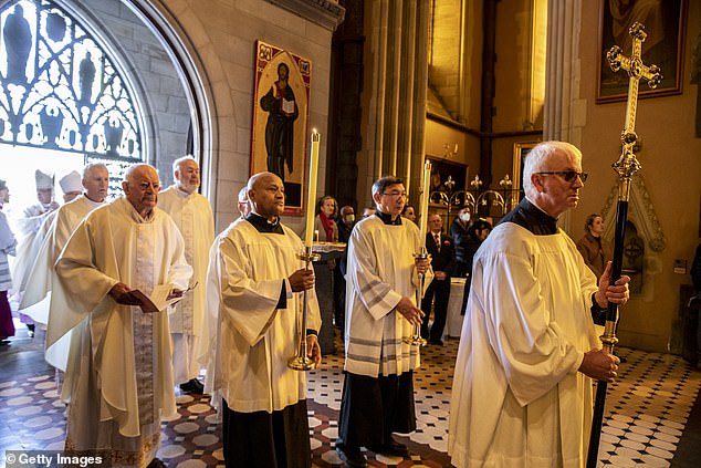 The Clergy are seen preparing to enter the state funeral service for the well-respected priest