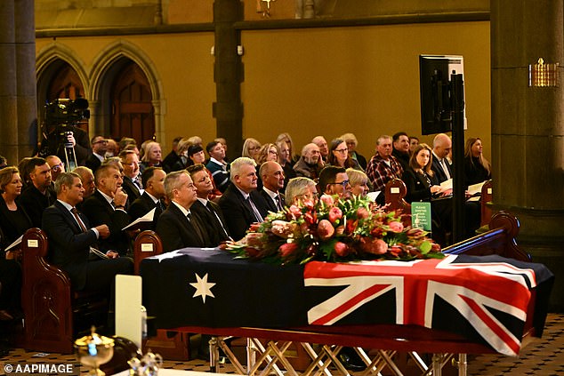 Former Victorian Premiers Steve Brack, Jeff Kennett and Federal Minister for the NDIS Bill Shorten are seen in the second row beside Father Maguire's casket