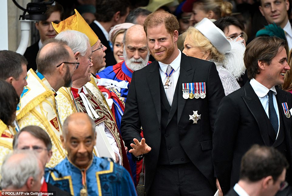 Prince Harry gives a wave as he makes his way out of Westminster Abbey following the Coronation of King Charles