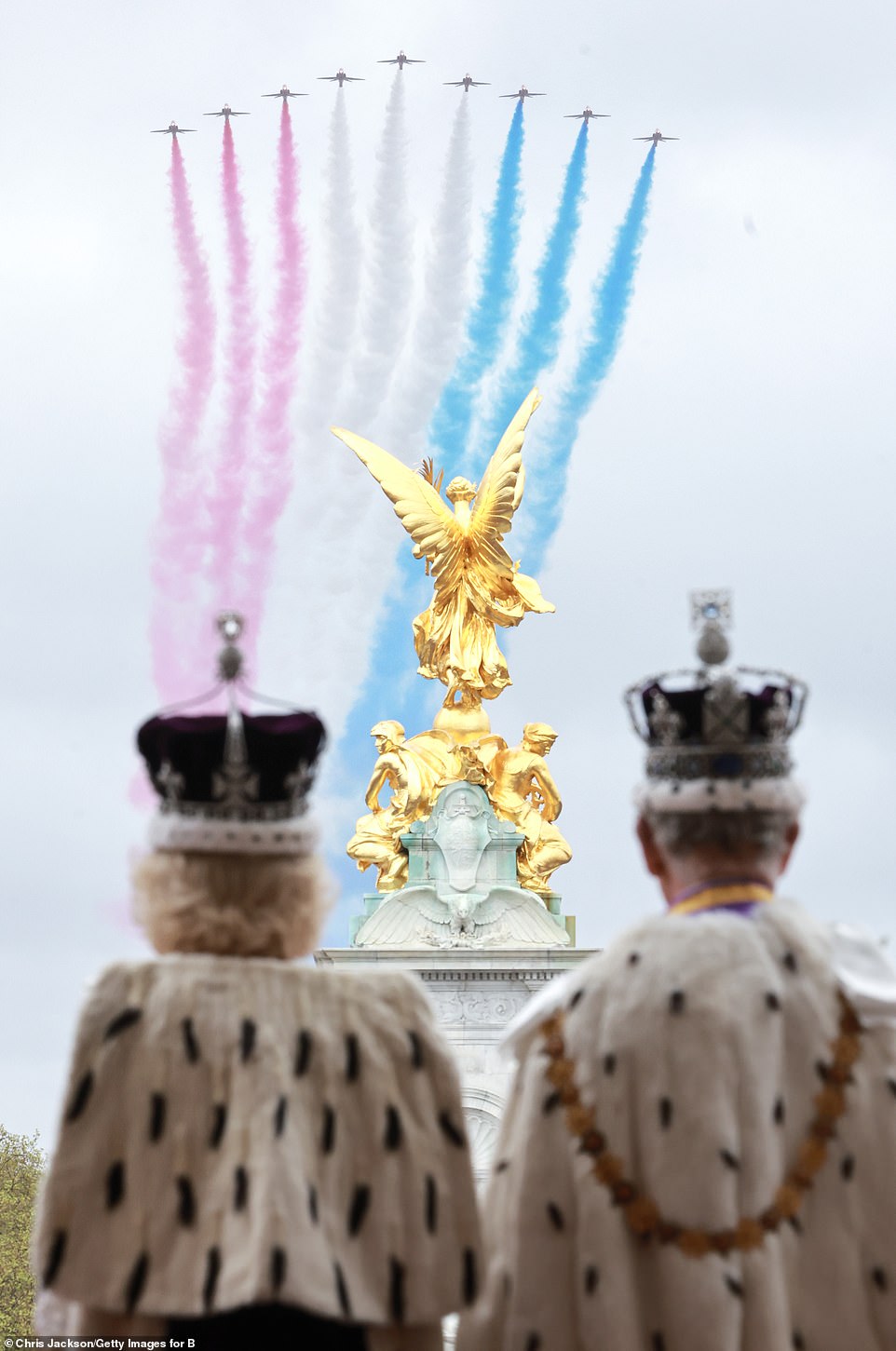 Charles and Camilla are seen admiring the Red Arrows' flypast which took place during the Coronation today in another image released by Buckingham Palace