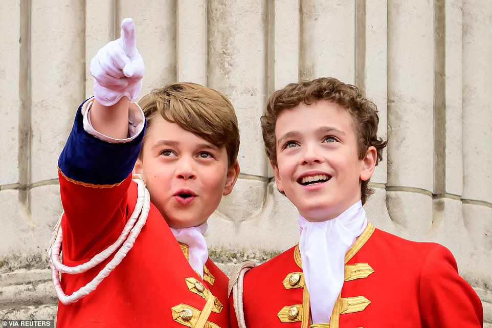 Prince George (L) points while on the balcony of Buckingham Palace