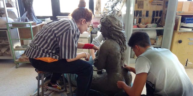 Bildhauer im Studio arbeiten an einer Meerjungfrau-Statue