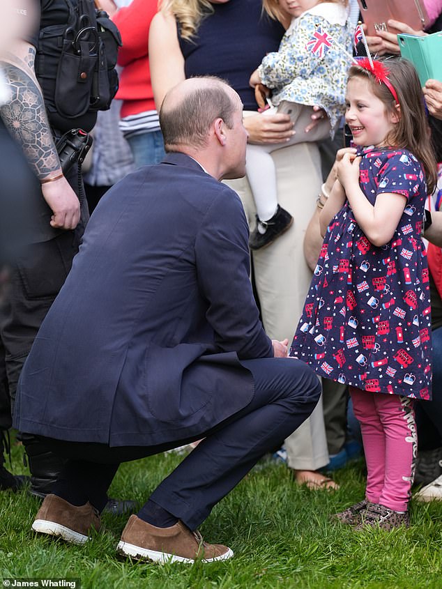 Prinz William spricht mit einem jungen Mädchen, als er königliche Fans vor Schloss Windsor begrüßt