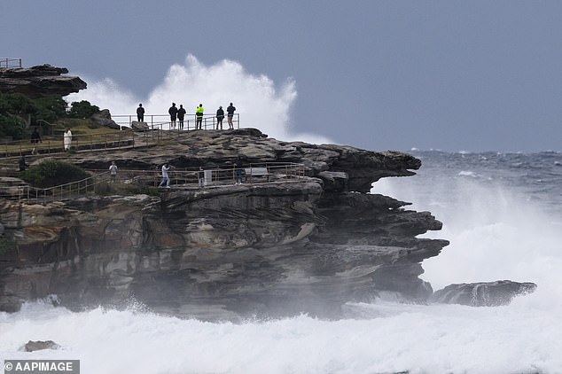 Massive Wellen zogen am Montag viele neugierige Strandbesucher an.  Abgebildet sind Wellen, die bei Bondi gegen die Felsen schlagen