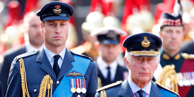 Prinz William geht hinter seinem Vater King Charles her, während beide Militäranzüge tragen