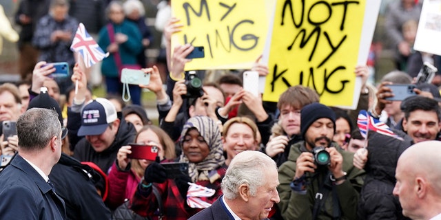 König Charles schaut während einer königlichen Verlobung von Demonstranten weg