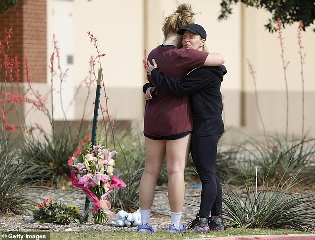 MacKenzie Bates umarmt ihre Mutter Rochelle, wo am Tatort Blumen zurückgelassen wurden