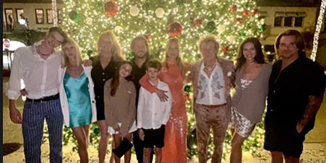 Rod Stewart mit seiner Frau und seinen Kindern vor einem Weihnachtsbaum