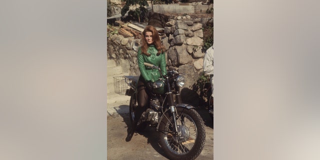 Ann-Margret im kurzen grünen Kleid auf einem Motorrad