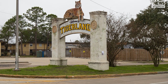 Auf einem Schild steht: "Willkommen im Tigerland" mit einem künstlichen Tiger, der oben sitzt.