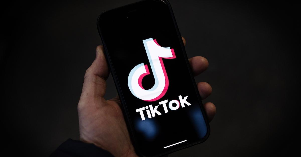 Eine Person hält ein Telefon mit dem TikTok-Logo auf dem Bildschirm