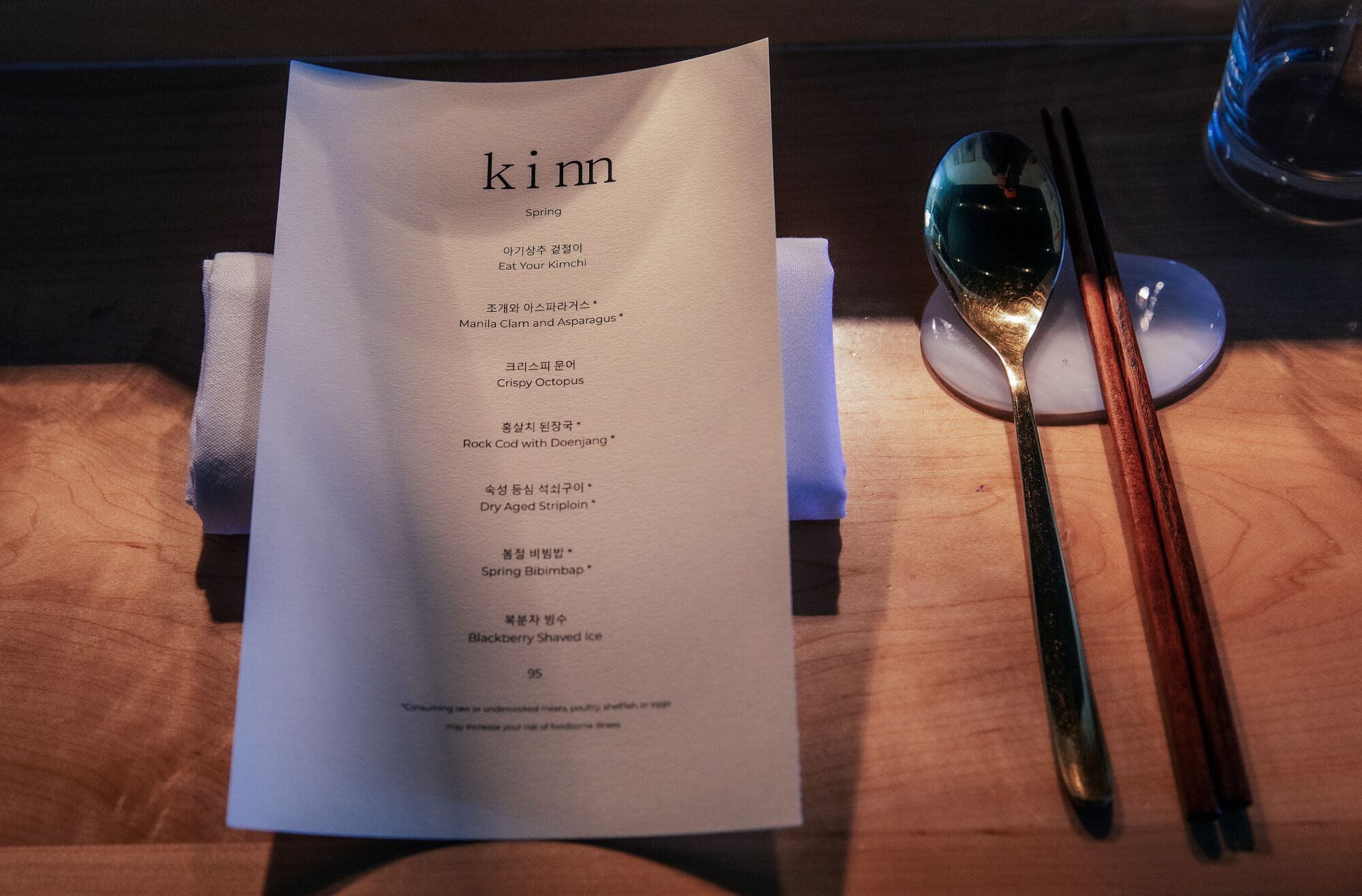 Im Kinn, einem kleinen Restaurant mit Degustationsmenü in der 6th St. in Koreatown, werden ein gedeckter Tisch und ein Menü auf der Theke platziert.