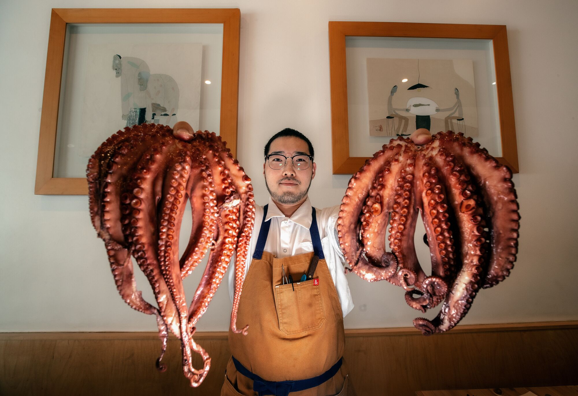 Chefkoch/Inhaber Ki Kim hält in seinem Restaurant Kinn einen spanischen Oktopus hoch.