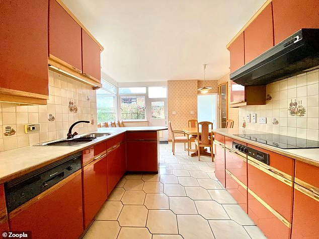 Die erweiterte Küche ist in Brauntönen mit cremefarbenen Fliesen und einer beige gemusterten Tapete gehalten