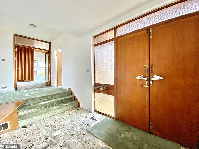 Der Zugang zum Anwesen erfolgt durch eine doppelte Haupttür, die über einen seitlichen Glasanbau mit einem Briefkasten verfügt