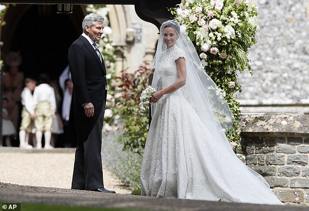 Pippa  dazzled guests in her bespoke lace gown by British designer Giles Deacon. Pictured: with her father Michael outside the church