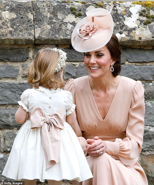 Kate beams as she speaks to her then two-year-old daughter Charlotte, who was a bridesmaid at Pippa's wedding