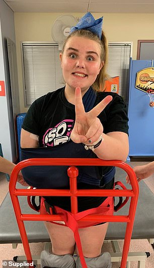 Lily is pictured in physiotherapy  learning to  stand again